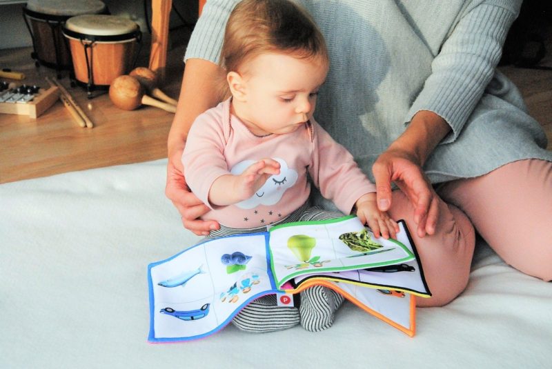 עיצוב חדרי תינוקות עם תינוקת על הרצפה קוראת ספר